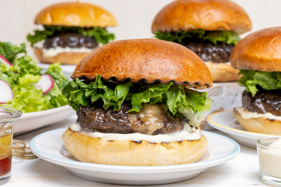Burgers de bœuf farcis au fromage suisse sur le barbecue